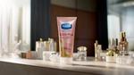 A tube of Vaseline's Gluta-Hya Dewy Radiance serum-in-lotion displayed among various skincare products on a countertop.