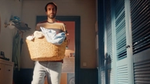 Man carrying a laundry basket in a room.