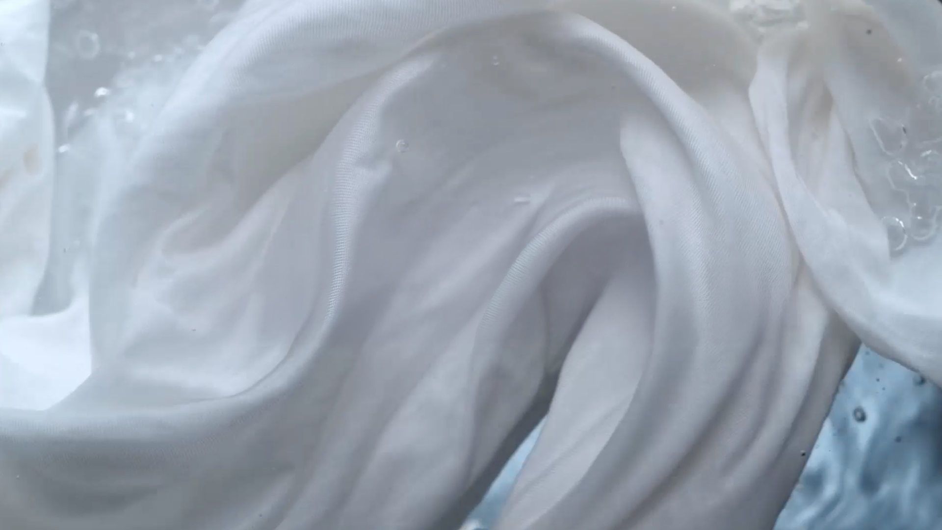 Close-up of white fabric submerged in water.