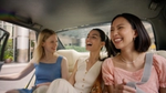 Friends laughing in the bac of a car