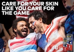 Two male French fans celebrate together, beside a call to action from Dove Men+Care to care for your skin like you care for the game.
