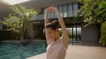 Woman stretching by a pool in sunlight.